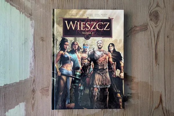 Komiks "Wieszcz. Księga 2" od wydawnictwa Lost In Time leżący na drewnianym stole.