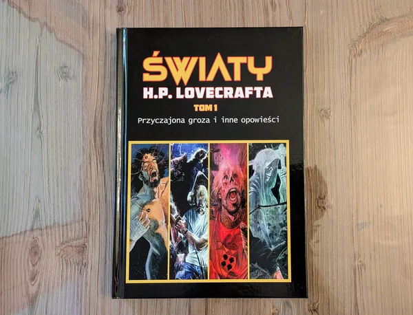 Komiks „Światy H. P. Lovecrafta. Tom 1" leżący na drewnianym stole